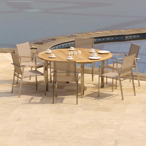 Outdoor teak dining table and chairs beside a swimming pool