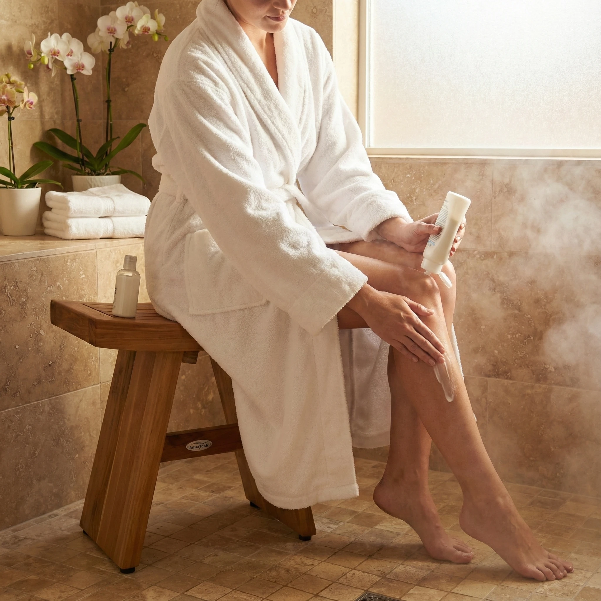 Person seated on an AquaTeak bench in a warm-toned bathroom