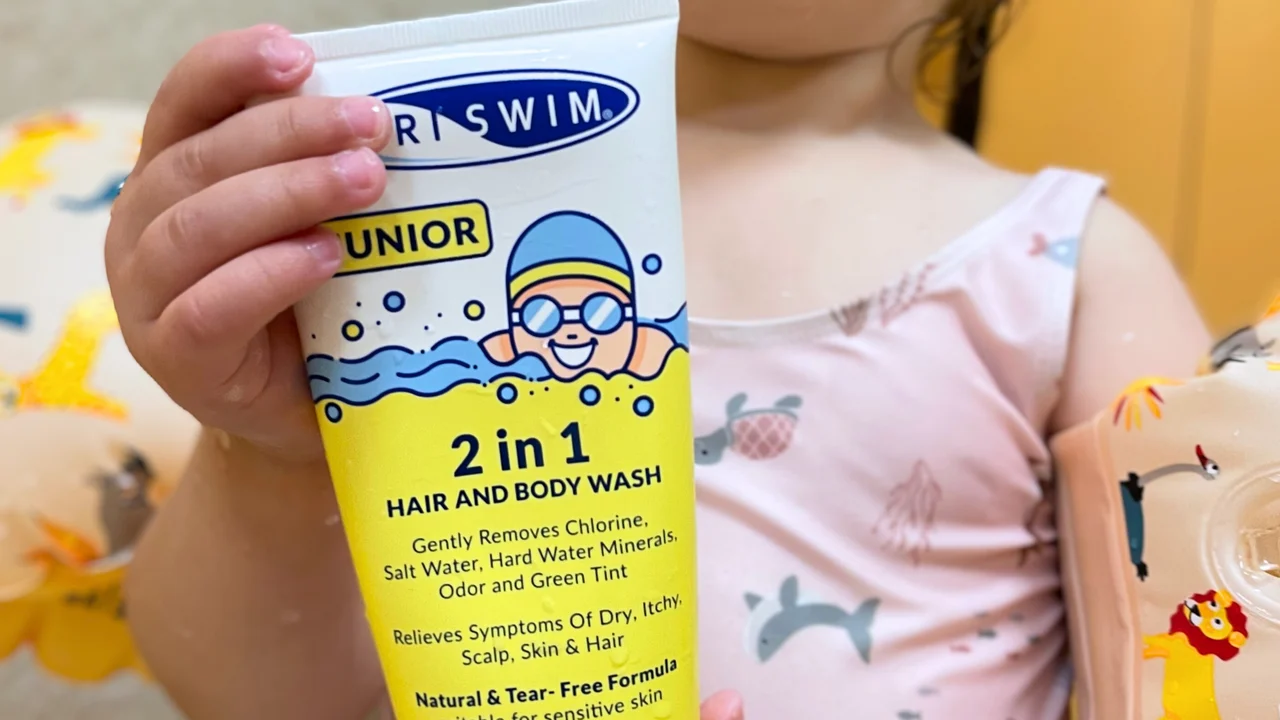 TRISWIM Junior 2 in 1 hair and body wash held beside a child